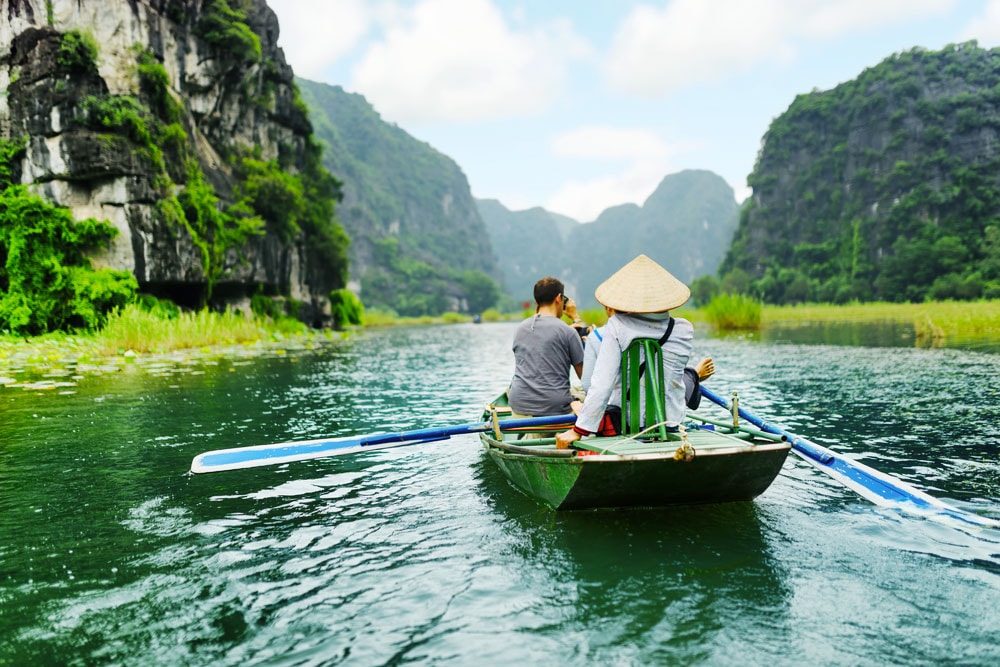 Floating on a small boat around Trang An complex promises memorable experiences